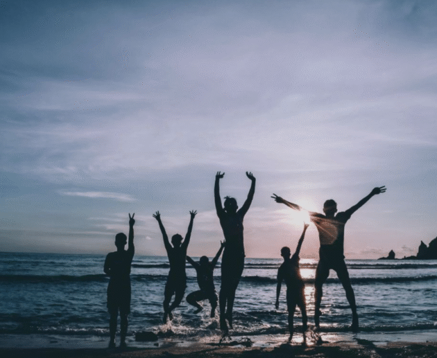 une famille heureuse à la mer au sunset de dos en afrique du sud