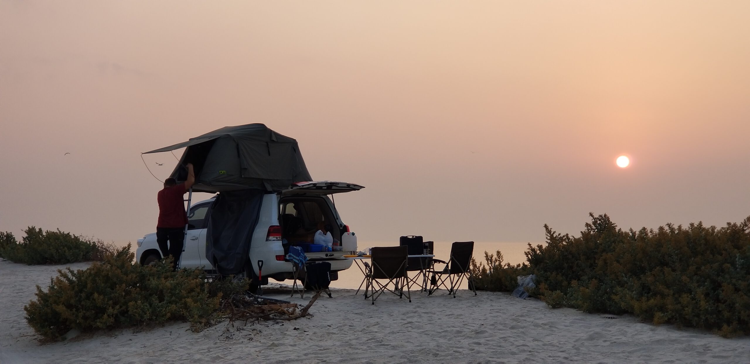 Van aménagé et 4x4 aménagé face aux paysages désertiques d’Oman
