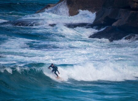 Surfeur en combinaison intégrale sur une vague de la péninsule de Reykjanes en Islande
