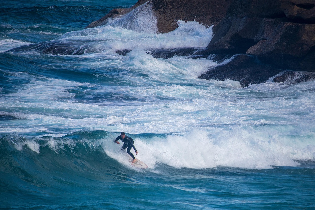 Surfeur en combinaison intégrale sur une vague de la péninsule de Reykjanes en Islande