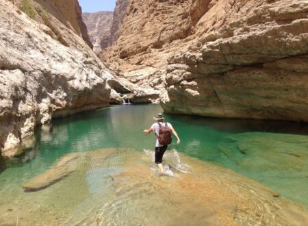 un voygauer se biagnant dans un wadis à Oman durant son road trip en 4X4 aménagé de location